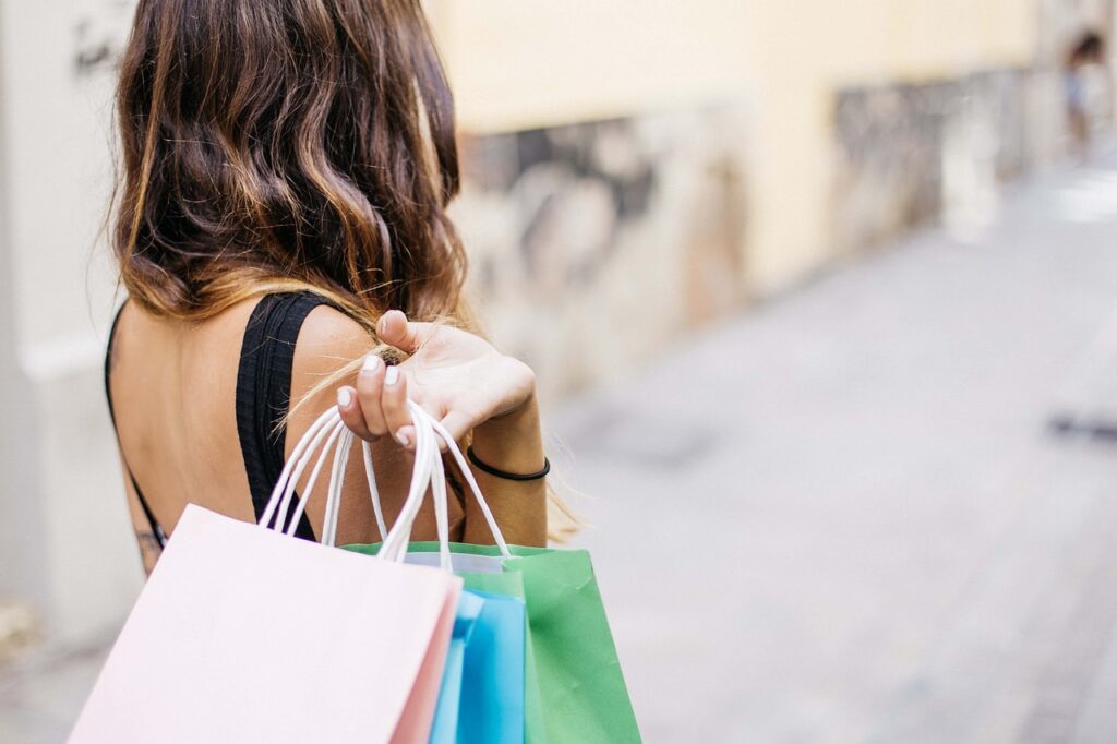 Mulher segurando sacolas de compras representando o aumento de vendas durante a Black Friday 2024